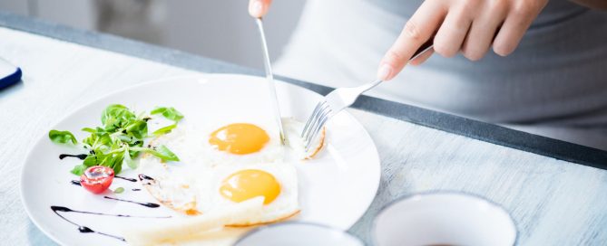 mujer comiendo huevos fritos fuente de proteína